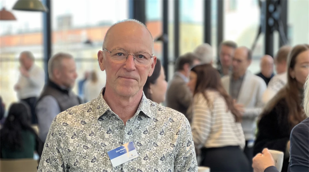 En man med glasögon tittar in i kameran. 