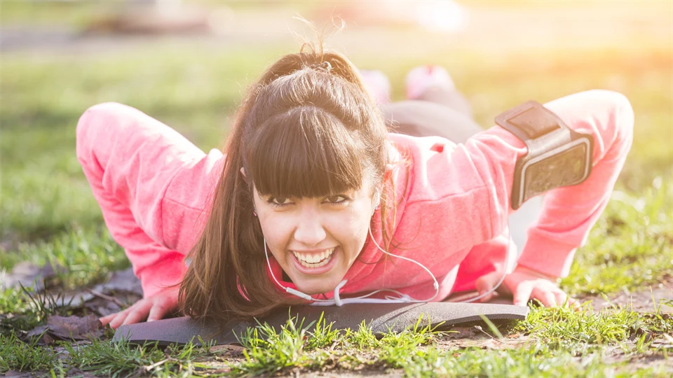 Young woman doing push ups exercises in the grass