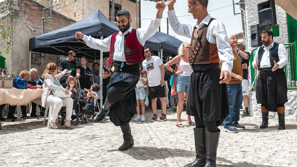 Two cypriotic men in traditional clothes are dancing in the streets