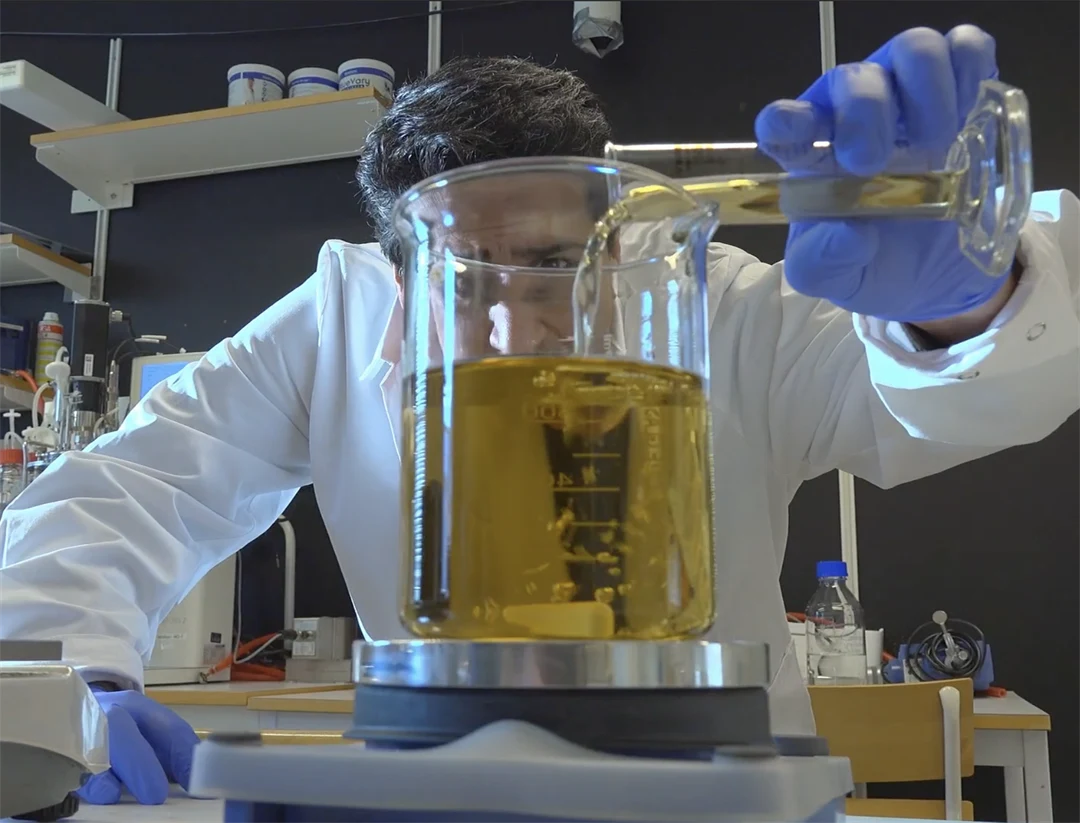 en man häller matolja i laboratorieglas