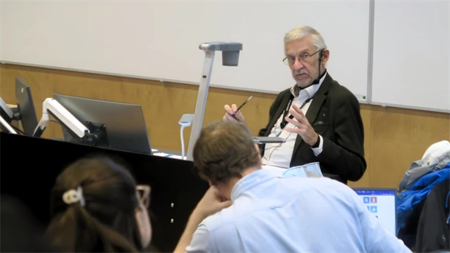 Manlig lärare föreläser i ett klassrum 