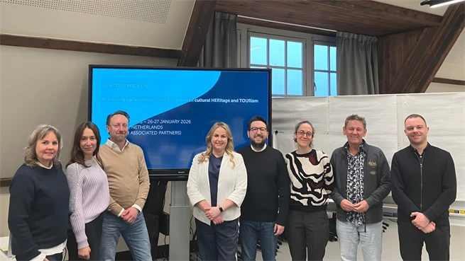 Åtta forskare, kvinnor och män, står i en föreläsningssal framför en tv-skärm