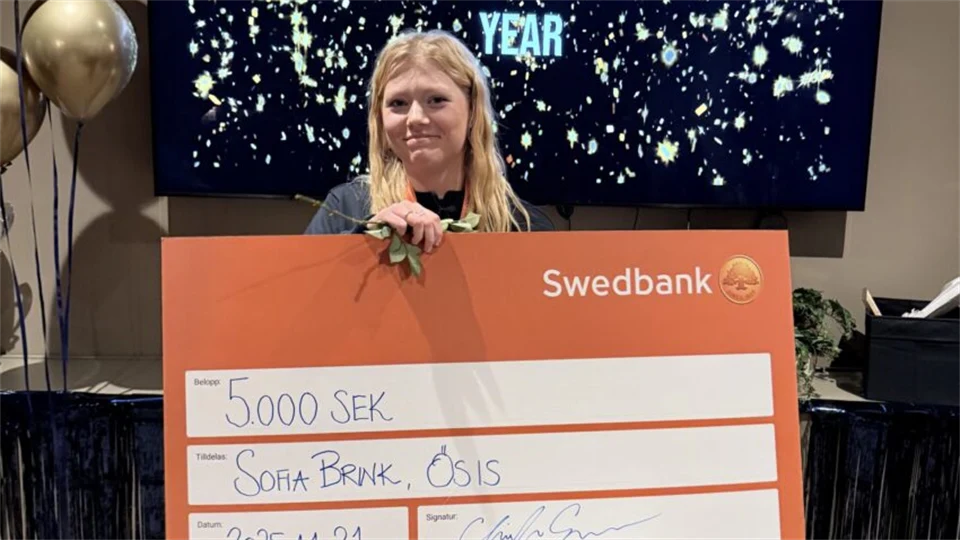 Person som visar upp prispengar kort från Swedbank.