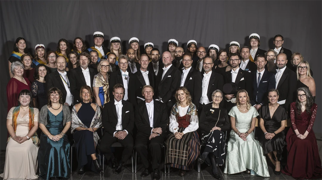 En gruppbild med drygt 50 finklädda personer. 