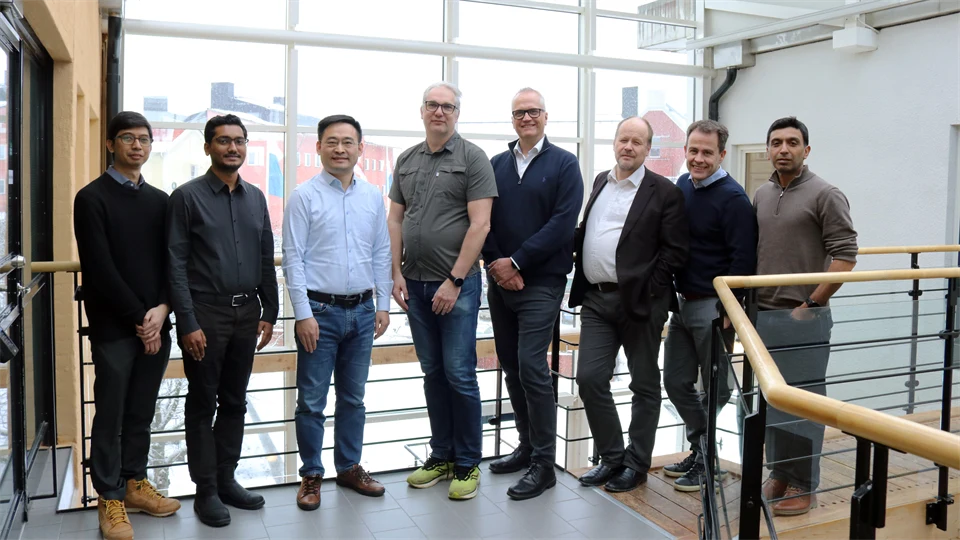 8 men stand lined up and smile at the camera