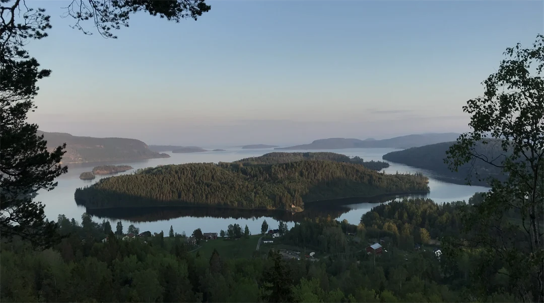 Utsikt över skogsklädda öar i stilla vatten.