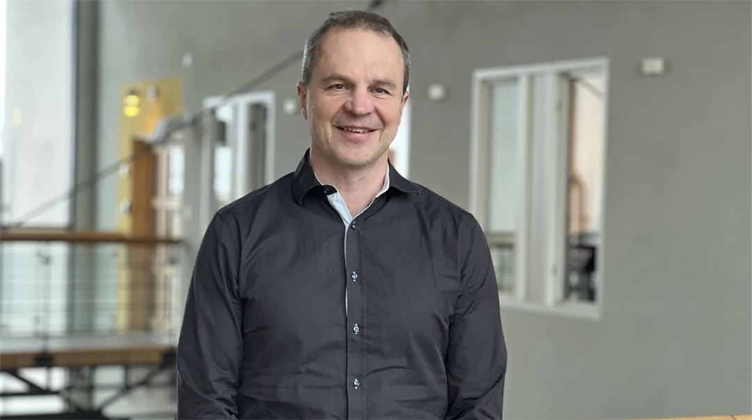 En man ler och tittar in i kameran.