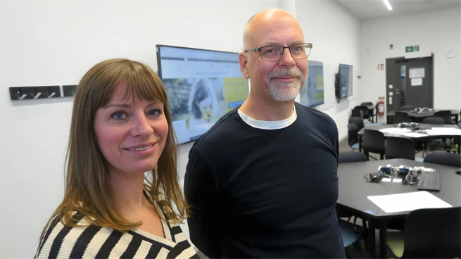 Två medarbetare från Mittuniversitetet, en kvinna och en man, står i salen där workshoppen hölls