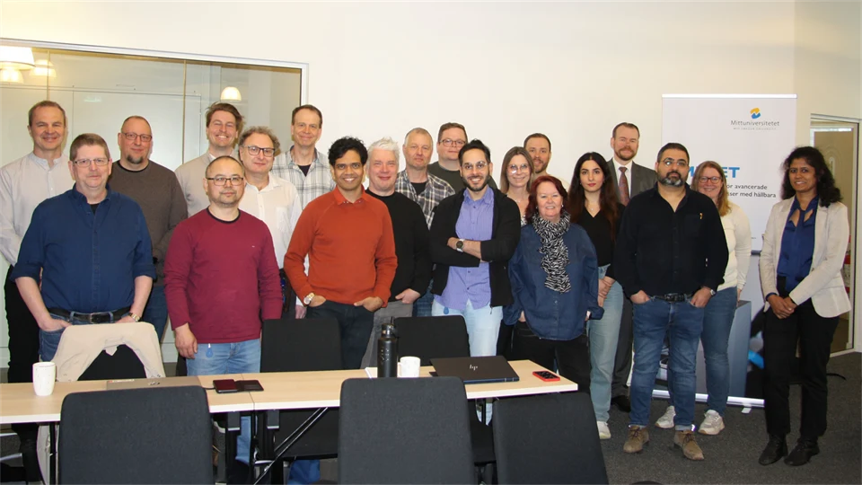 En grupp personer står tillsammans i ett konferensrum.