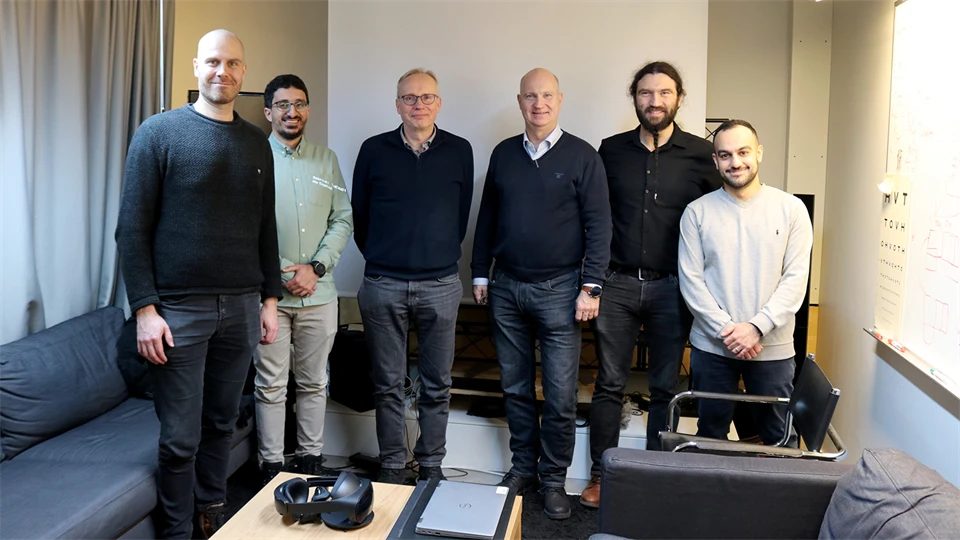 Sex stycken män står och tittar in i kameran och ler.