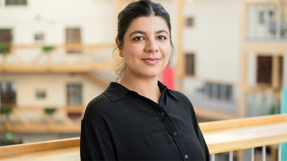 A woman in black, with her hair done up and wearing a black blouse. 