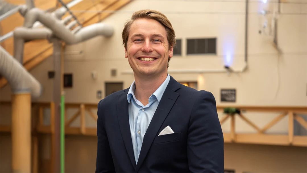 En man i kavaj ler mot kameran