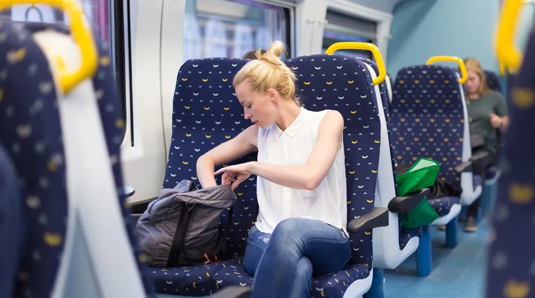 kvinna som åker tåg letar i sin väska