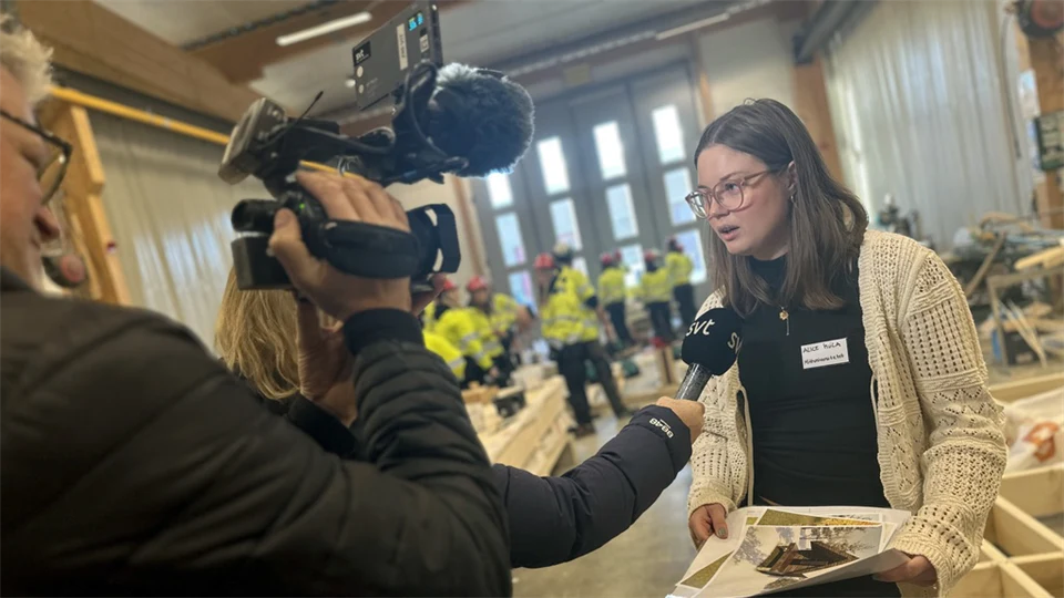 en kamera som filmar en intervju och en ung kvinna som pratar i en mikrofon