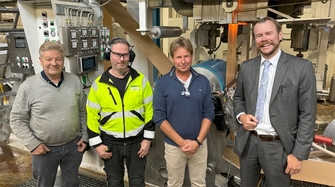 Four men standing together in an industrial building