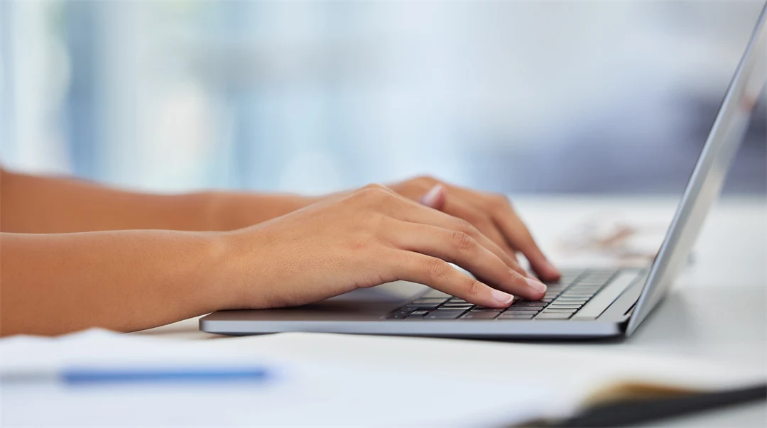 Två händer om skriver på en laptop