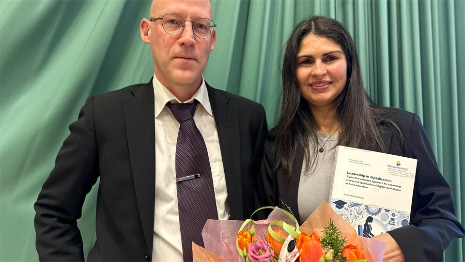 En man utan hår och med glasögon står bredvid en kvinna med långt svart hår