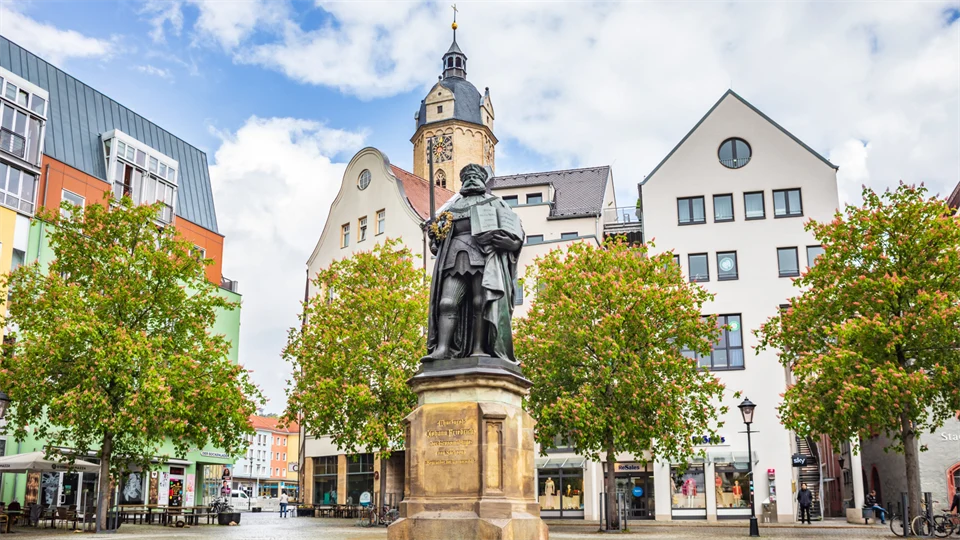 Staty på ett torg med byggnader i bakgrunden