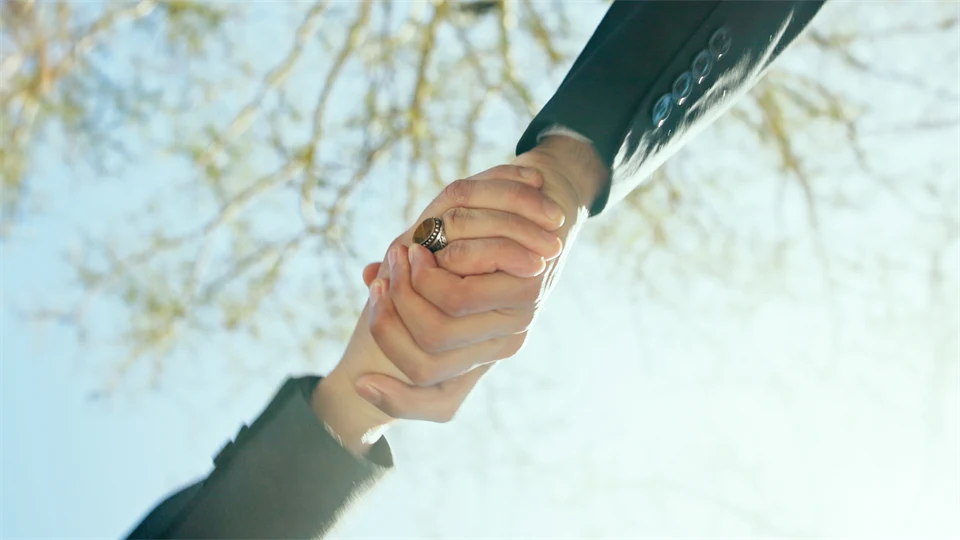 Två händer som håller i varandra utomhus