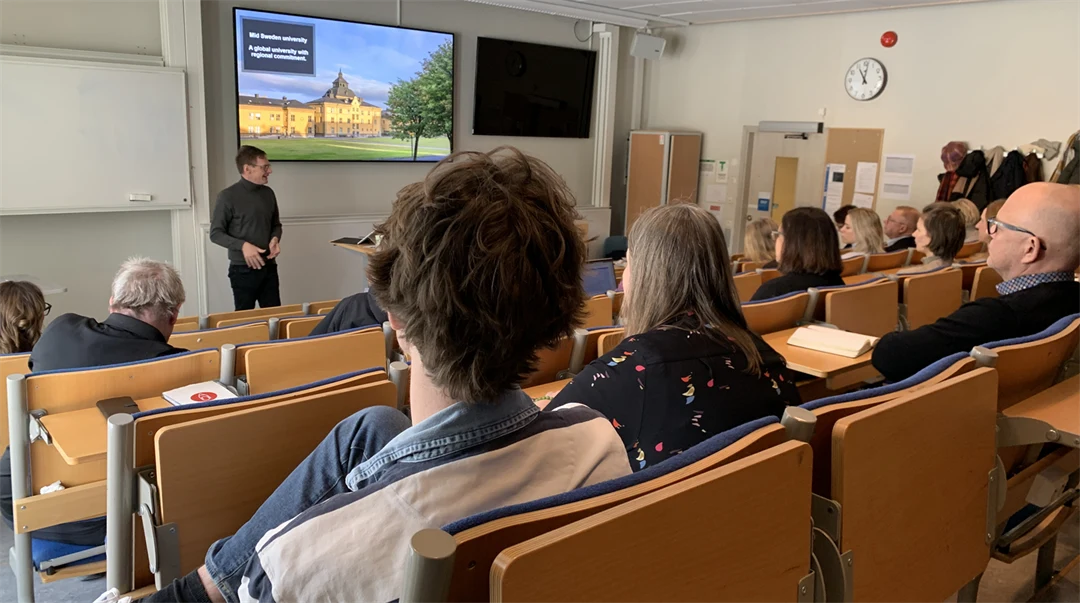 En föreläsare i ett klassrum med åhörare.