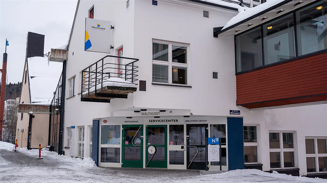 En vit byggnad med entré och balkong