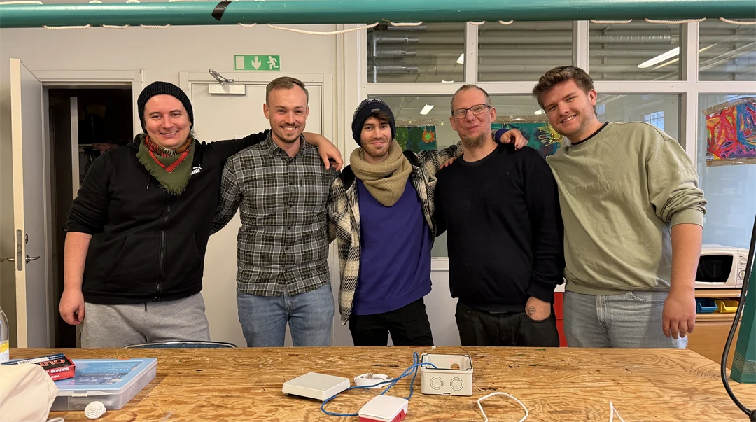 five people in front of a box