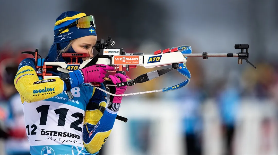Skidskytten Stina Nilsson står och skjuter mot tavlan i WC-premiären i Östersund.