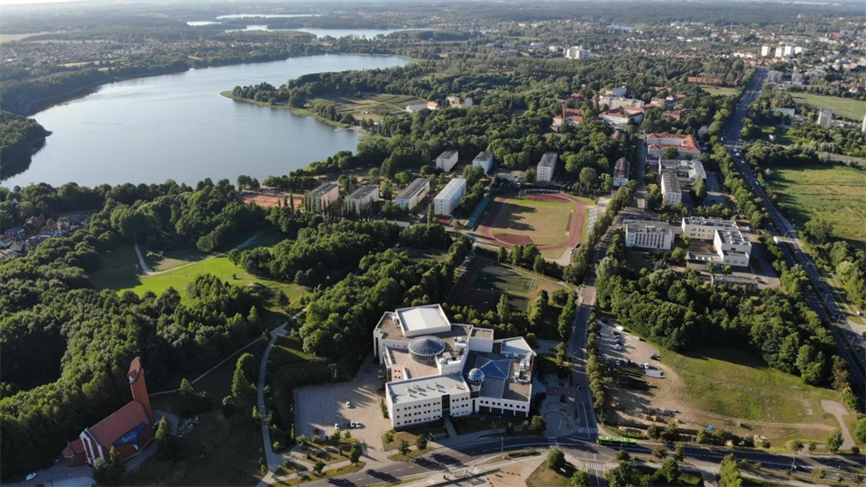 Översiktsbild skog, byggnader och vatten