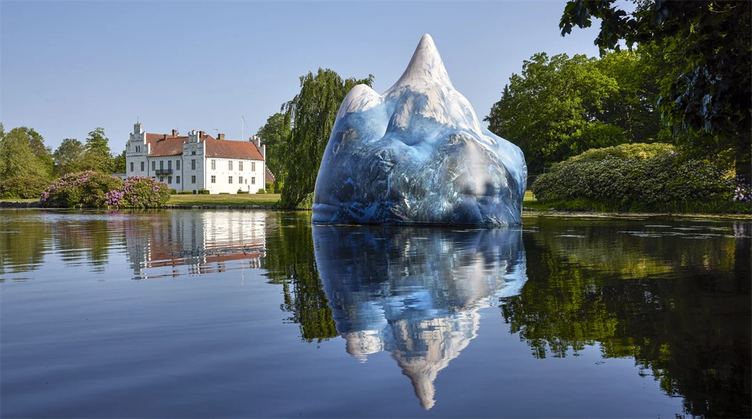 Ett uppblåsbart fjäll flyter på vattnet framför ett slott