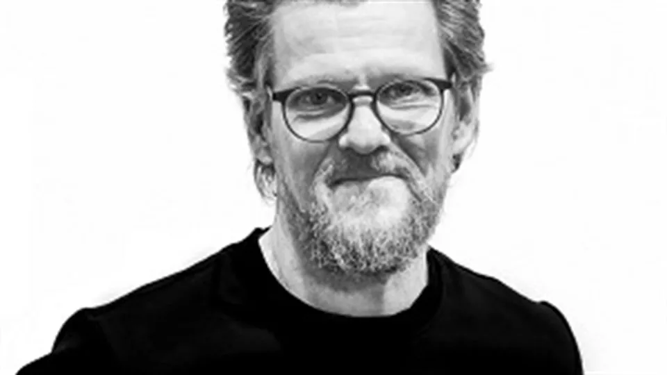 En man i glasögon som tittar på kameran