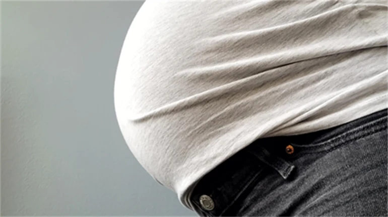 Gravid kvinna visar magen.