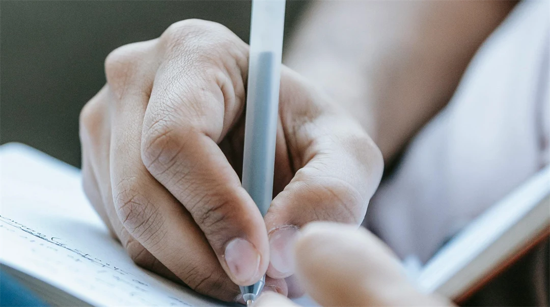 Hands writing on paper