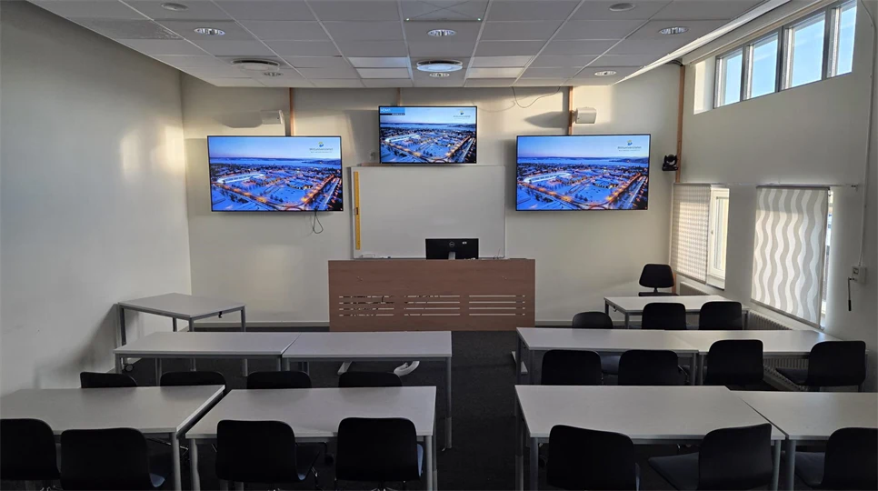 Lärosal med stolar och bord. Bildskärm