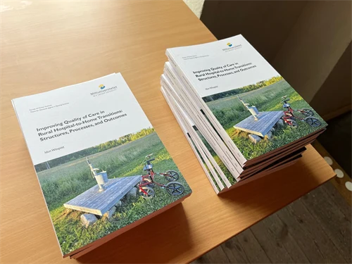 Två travar med böcker ligger bredvid varandra på ett träbord.