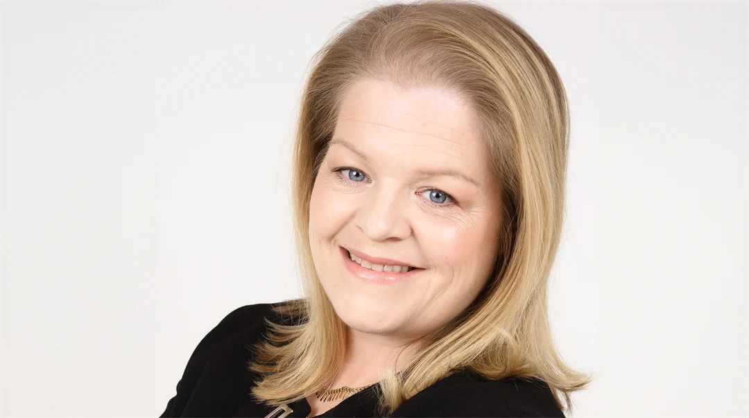 Kvinna med axellångt blont hår och svart kavaj i en porträttbild.