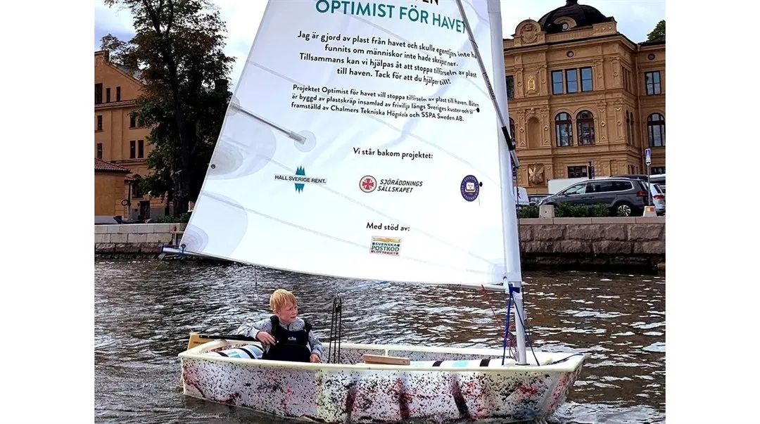 Optimistjolle av plast med skräpa-inte-ned-budskap på seglet