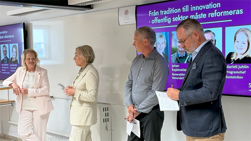 En panel med fyra personer under ett seminarium