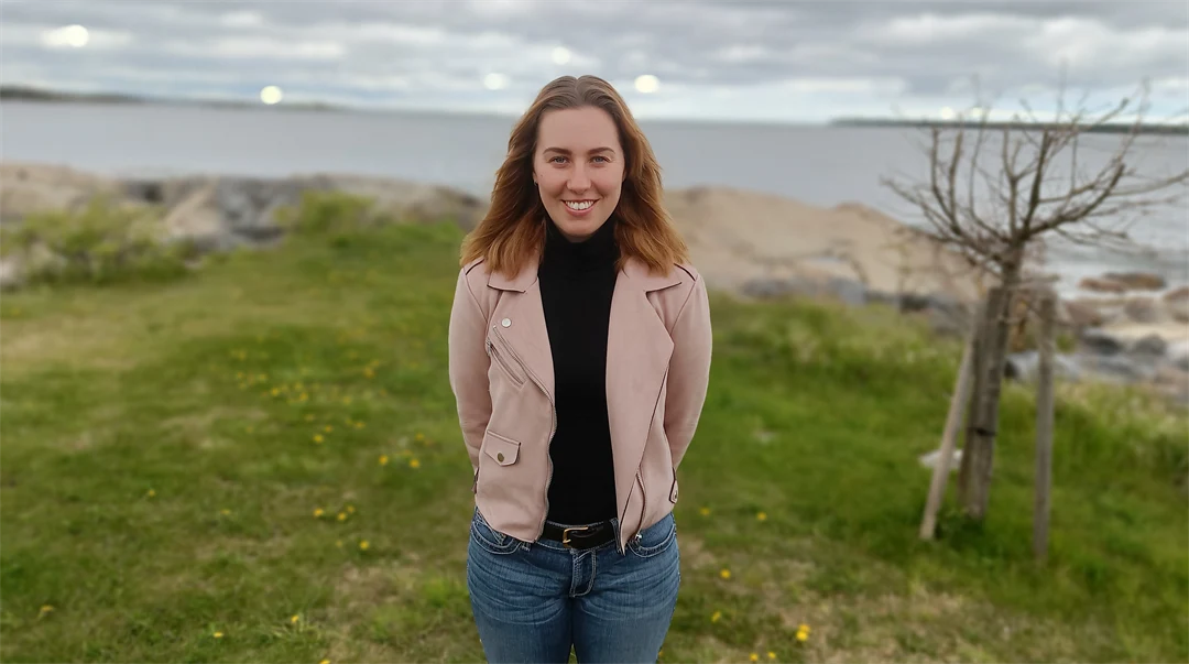 Kvinna med brunt hår och en rosa jacka