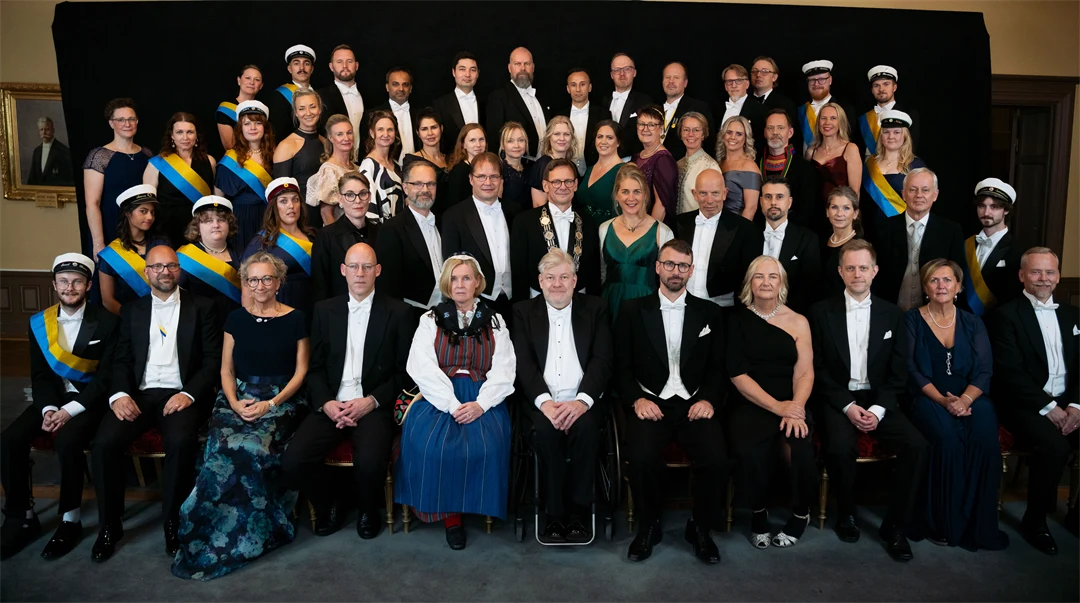 Gruppbild med högtidsklädda personer som sitter och står.