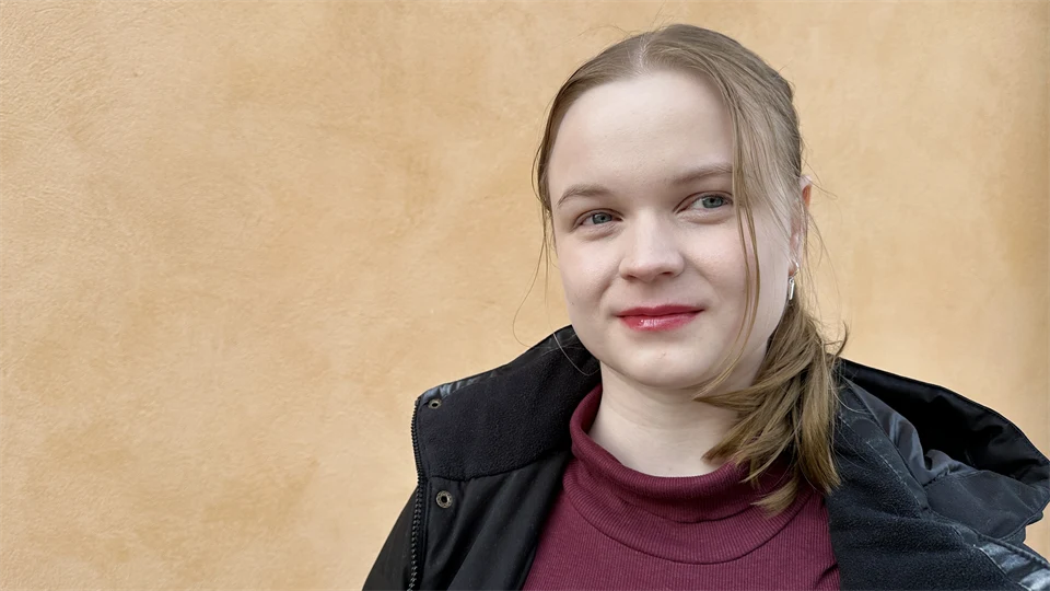 Ung tjej står framför en gul vägg