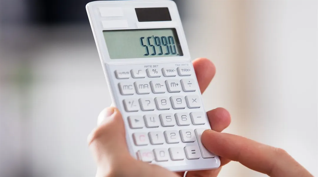 Person som håller i en miniräknare.