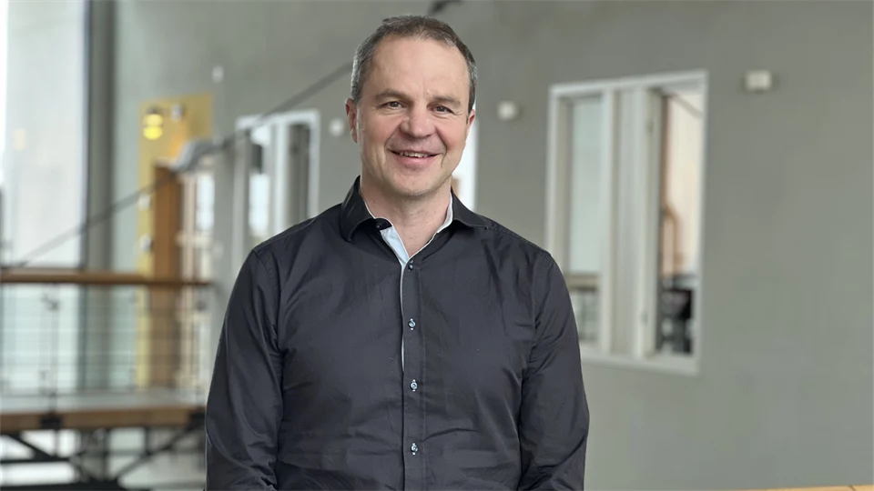 A man smiles and looks into the camera.