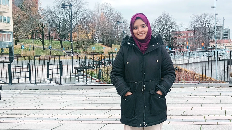 en kvinna står i stadsmiljö