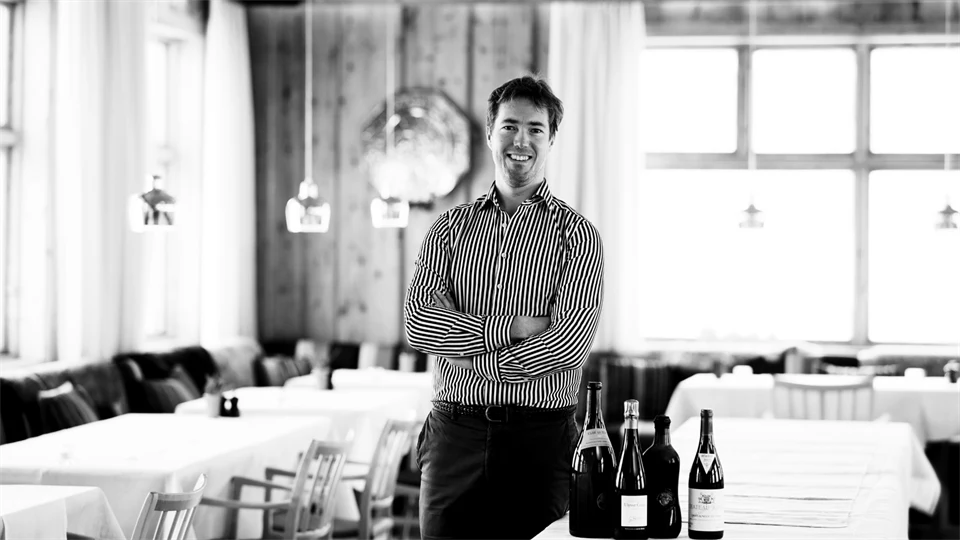 Svartvit bild på en man som står i en restaurang.