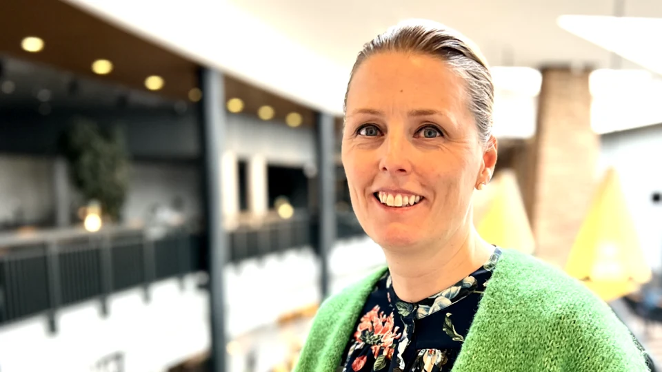 En blond kvinna med en grön tröja