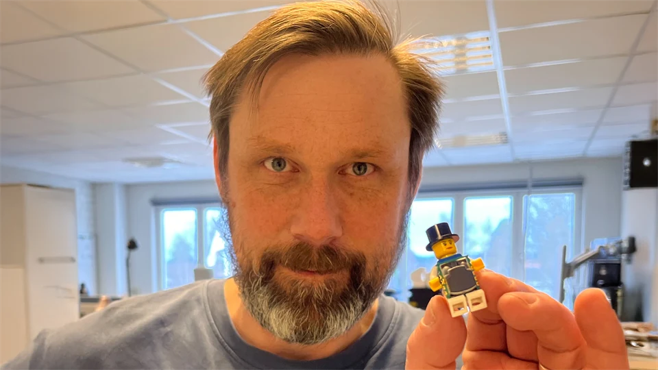 En man håller i en legofigur.