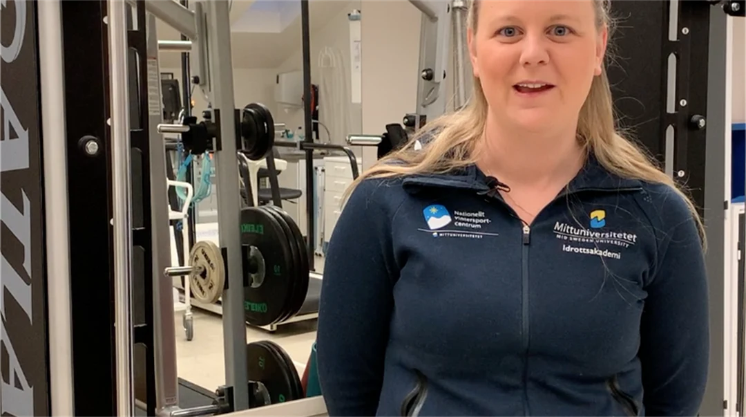 Kvinna står framför en träningsmaskin