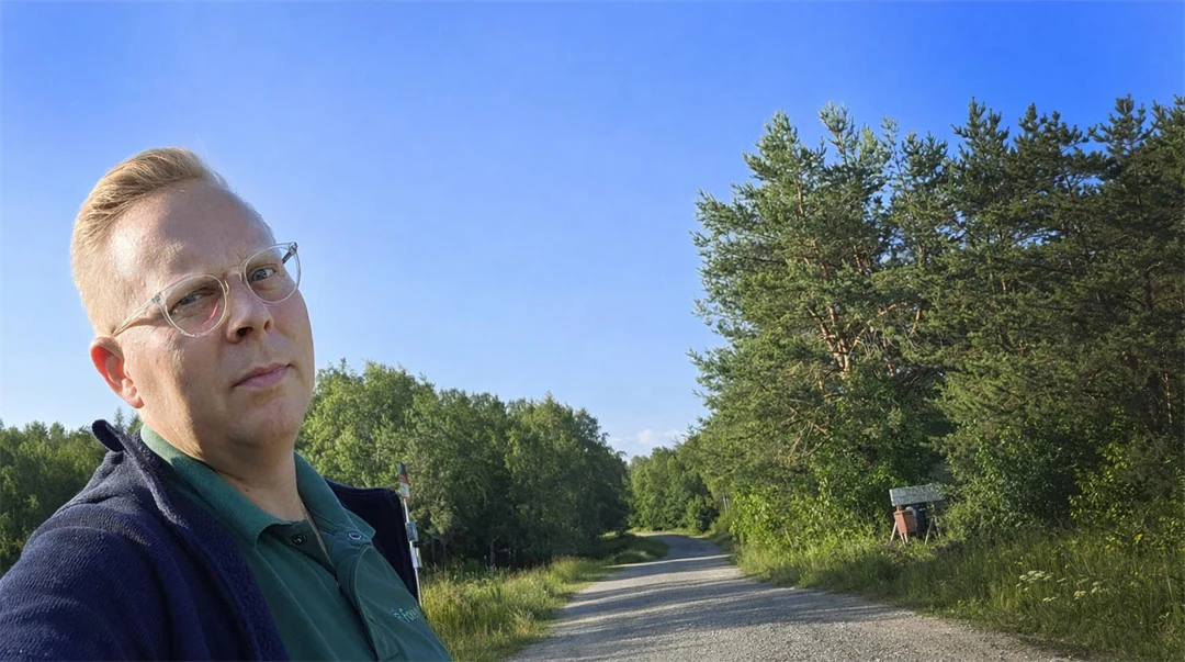 En man står vid en grusväg.