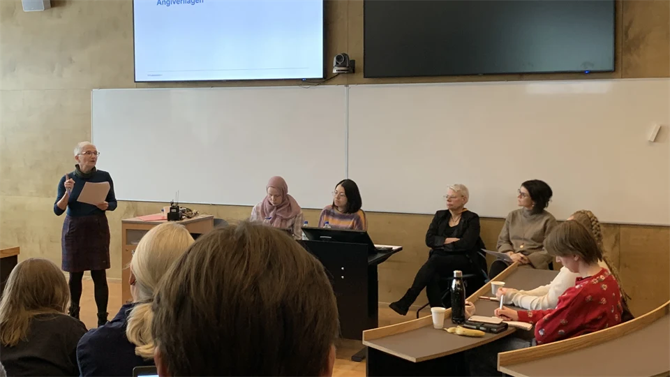 Fem personer i en panel framför åhörare i seminariesal.
