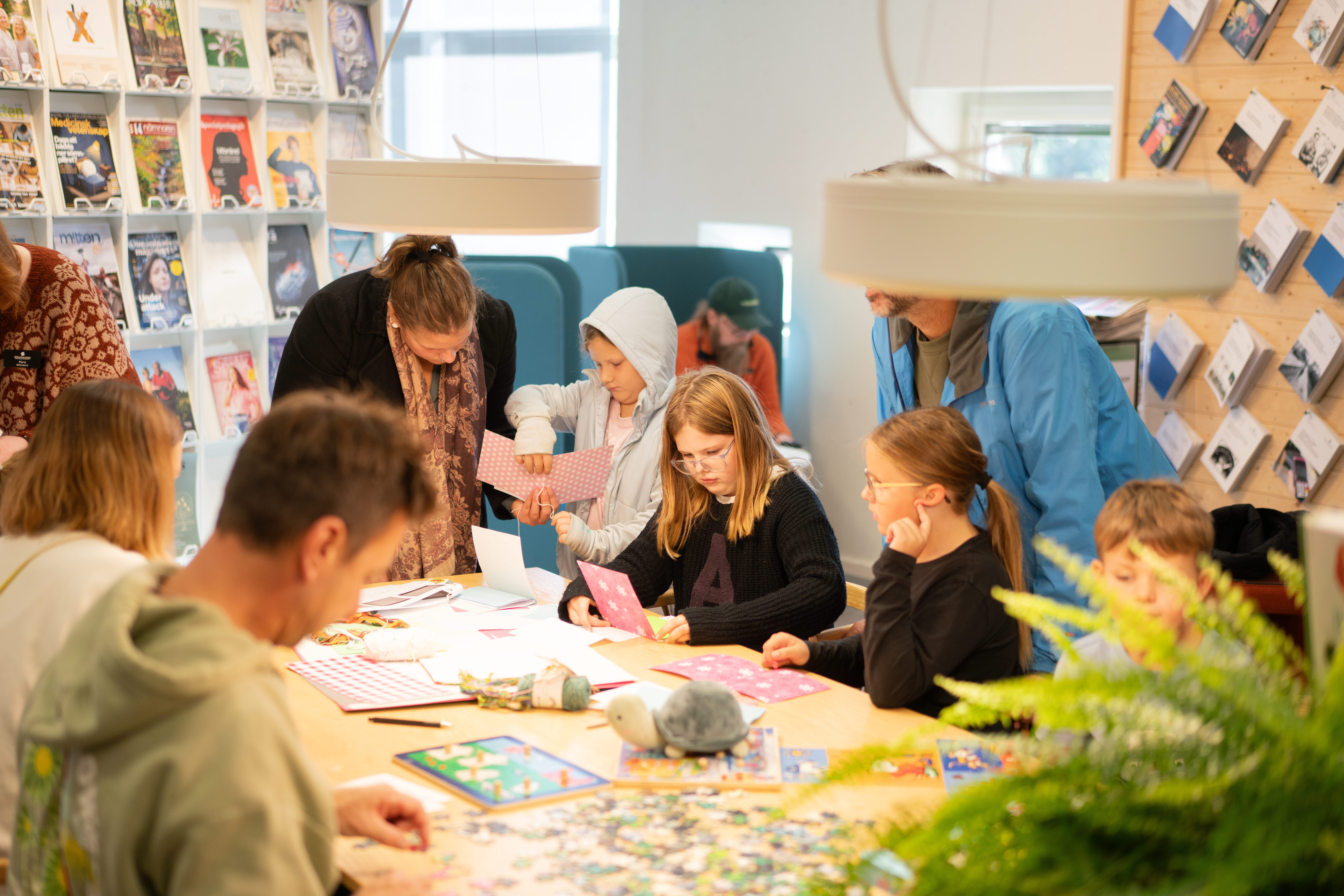 Children are sitting at a table doing crafts.